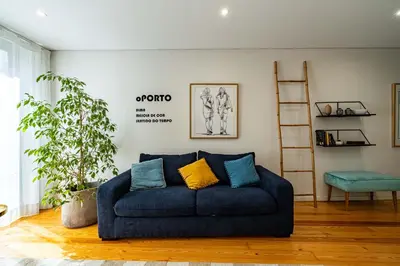 a living room with a blue couch and a ladder at HM - Vagus Oporto House in Porto