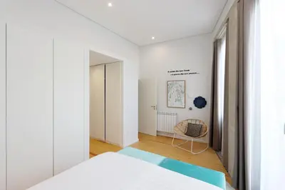 a bedroom with a bed and a chair in it at HM - Vagus Oporto House in Porto