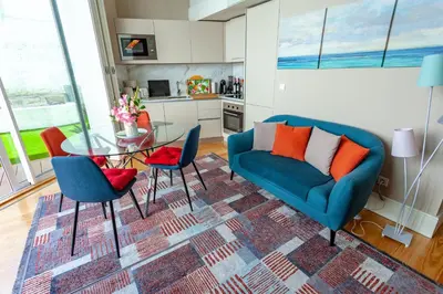 a living room with a blue couch and a glass table at Oporto City View - Flora Garden in Porto