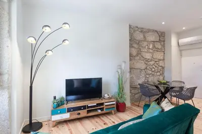 a living room with a green couch and a flat screen tv at Swimming Pool Luxury House 1 in Porto