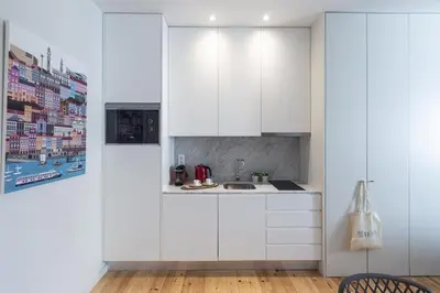 a white kitchen with white cabinets and a sink at Swimming Pool Luxury House 1 in Porto