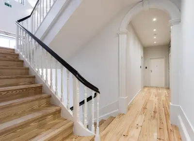 a hallway with white walls and a staircase with wood floors at Oporto Swimming Pool House in Porto