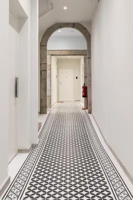 an empty hallway with a white door and a black and white tile floor at Oporto Swimming Pool House in Porto