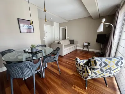 a living room with a table and chairs and a couch at New Oporto Apartments - São Bento in Porto