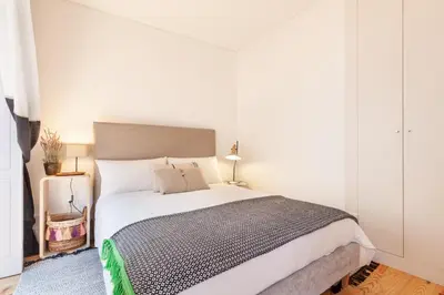 a bedroom with a large bed with white walls at D&S - Falling Leaves in Porto
