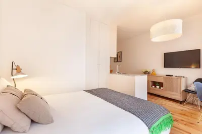 a white bedroom with a bed and a tv at D&S - Falling Leaves in Porto