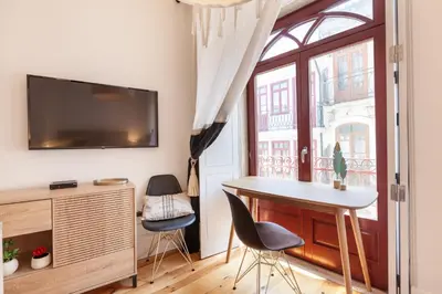 a living room with a table and chairs and a window at D&S - Falling Leaves in Porto