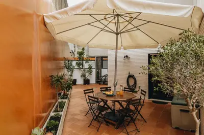a patio with a table and an umbrella at Douro Riverfront 2BR with Private Terrace & Garage in Porto