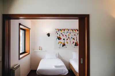 a bedroom with two beds and a picture on the wall at Douro Riverfront 2BR with Private Terrace & Garage in Porto