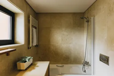 a bathroom with a shower and a toilet and a sink at Douro Riverfront 2BR with Private Terrace & Garage in Porto