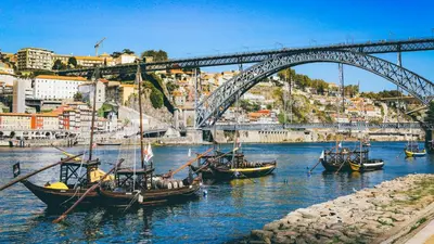 a group of boats in the water under a bridge at Douro Riverfront 2BR with Private Terrace & Garage in Porto