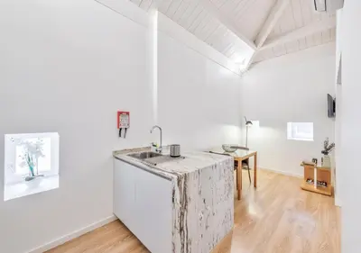 a kitchen with white walls and a marble counter top at Oporto Comfort Dom Hugo - Historic Apartments in Porto