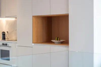 a kitchen with white cabinets and a bowl with a plant at LovelyStay - Primrose 2BR Flat with Free Parking, AC and Balcony in Porto
