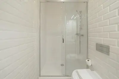 a white bathroom with a shower and a toilet at Cozy Flat with Terrace by Hosty in Porto
