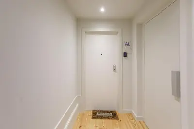 a hallway with a white door and a wooden floor at LovelyStay - Downtown Studio with Pool, AC and Balcony in Porto