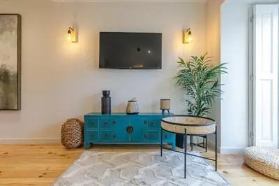 a room with a blue cabinet and a tv on a wall at LovelyStay - Downtown Studio with Pool, AC and Balcony in Porto