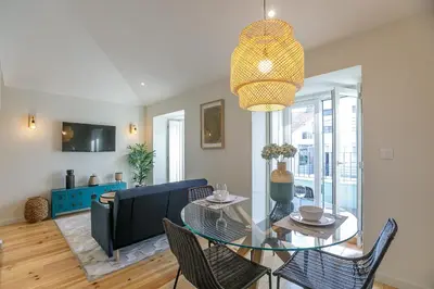 a dining room with a glass table and chairs at LovelyStay - Downtown Studio with Pool, AC and Balcony in Porto