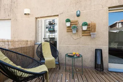 a patio with two chairs and a table and a window at Rua de Camões in Porto