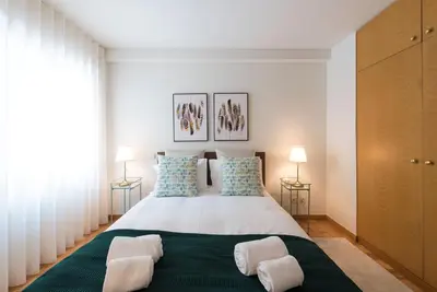 a bedroom with a large bed with two lamps at Rua de Camões in Porto