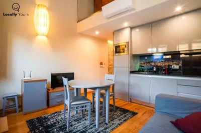 a kitchen and dining room with a table and chairs at Locally Yours Oporto Apartments in Porto