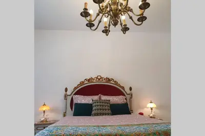 a bedroom with a large bed and a chandelier at Charming Clérigos Studio in Porto