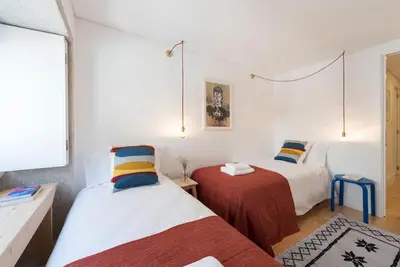 two beds in a room with white walls at PinPorto Downtown in Porto
