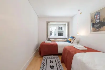 two beds in a small room with a window at PinPorto Downtown in Porto