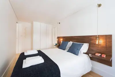 a bedroom with a large white bed with blue pillows at PinPorto Downtown in Porto