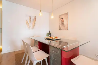 a kitchen with a red island and white chairs at Host Wise - Colorful Bright Flat with Balcony in Porto