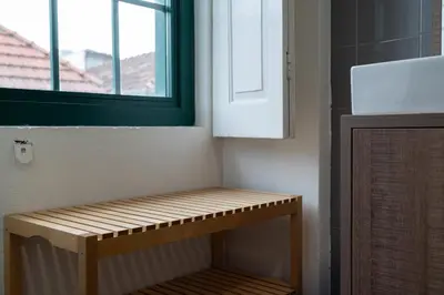 a wooden bench in a room with a window at Clerigos Townhouse Porto by PCH in Porto