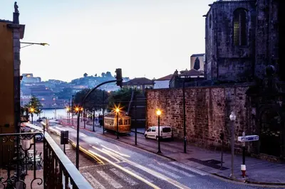 a train traveling down a city street at night at Beautiful Infante Apartment in Porto
