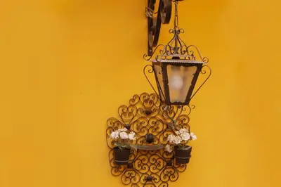 a balcony of a yellow house with two plants at Cedofeita Village Porto in Porto