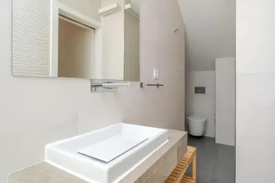 a white bathroom with a sink and a mirror at Decor Studios - Clérigos by Host Wise in Porto