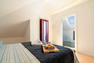 a room with a bed with a tray of fruit on it at Decor Studios - Clérigos by Host Wise in Porto