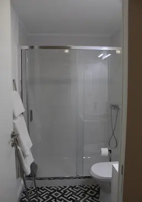 a bathroom with a glass shower with a toilet at Oporto Coliseum Studio in Porto
