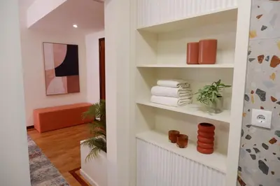a bathroom with white shelves with towels on them at Porto Family Home by MP - Renovated in Porto