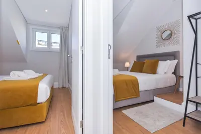 a bedroom with two beds and a window at Fontinha Square Apartments by Porto City Hosts in Porto
