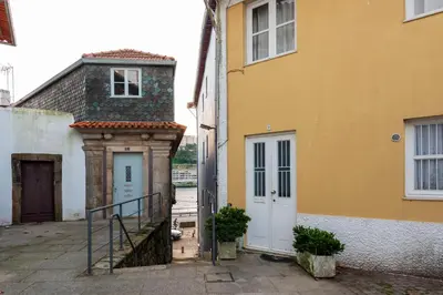 a yellow and white building with a door and stairs at Duplex Douro River in Porto