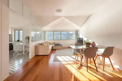 a dining room and living room with a table and chairs at Duplex Douro River in Porto