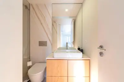 a bathroom with a sink and a toilet and a mirror at Duplex Douro River in Porto