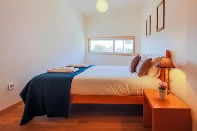 a bedroom with a bed with a table and a window at Porto Cathedral II in Porto