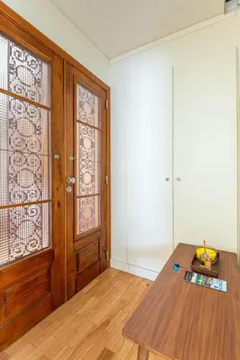 a room with a table and a wooden door at Bombarda Homes in Porto