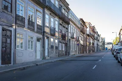 an empty street with cars parked on the side of a building at Solar Studio Fontainhas in Porto