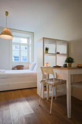 a bedroom with a bed and a table and a desk at Solar Studio Fontainhas in Porto