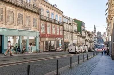 a street with buildings and people walking on the street at 118 Oporto Apartments in Porto