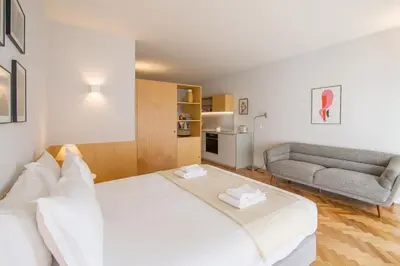 a bedroom with a large white bed and a couch at Cedofeita Studio 176 - Studio in city center in Porto