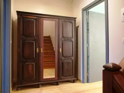 a wooden wardrobe with a mirror next to a staircase at 107 Rosario, Guesthouse in Porto