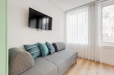 a living room with a couch and a flat screen tv at 7 Bridges Estúdios- Porto-houses and suites in Porto