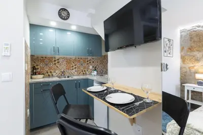 a kitchen with blue cabinets and a table with chairs at OportoHost Cozy Studios in Porto