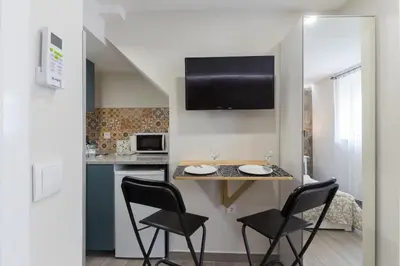 a kitchen with two chairs and a table in a room at OportoHost Cozy Studios in Porto